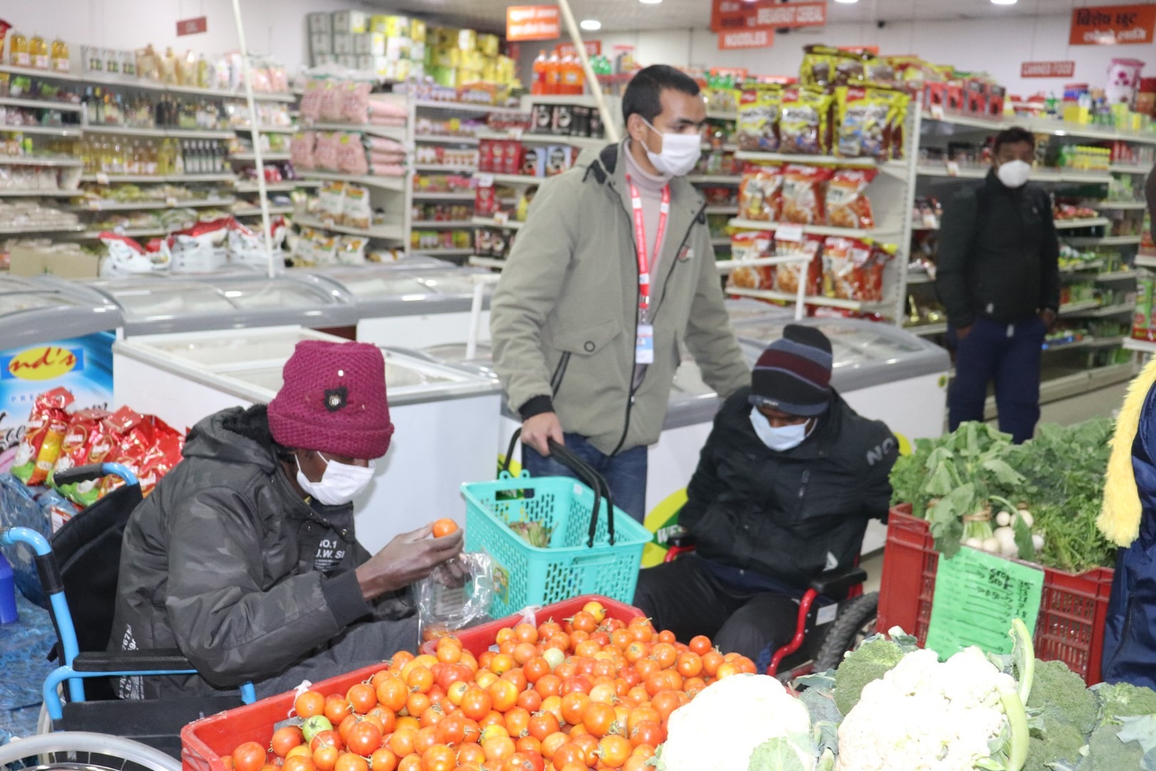 person in wheelchair buying vegetables